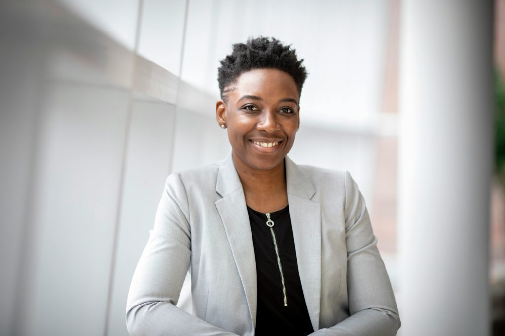 pexels-photo-2381069-2381069 Confident African American businesswoman smiling inside a modern office space.