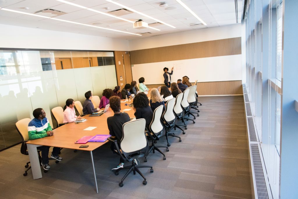 pexels-photo-1181394-1181394 A diverse group actively collaborating in a bright, modern conference room setting.