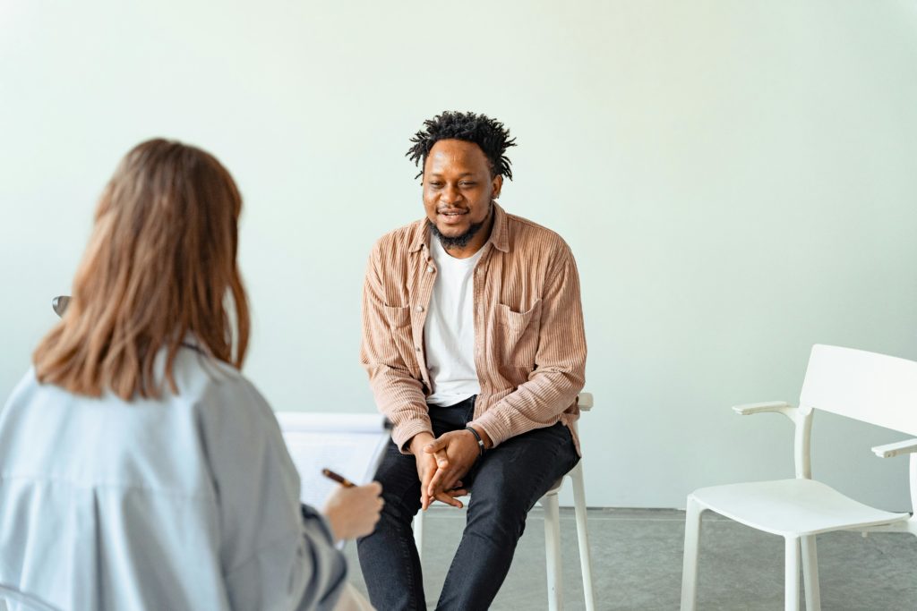 pexels-photo-7579312-7579312 A therapy session in a modern office setting with a counselor and a client engaged in conversation.